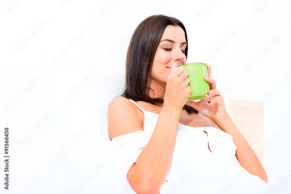 Beautiful young woman having her first coffee in bed Beautiful young woman having her first coffee in bed