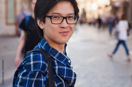 Asian man with glasses stand at street, closeup portrait.