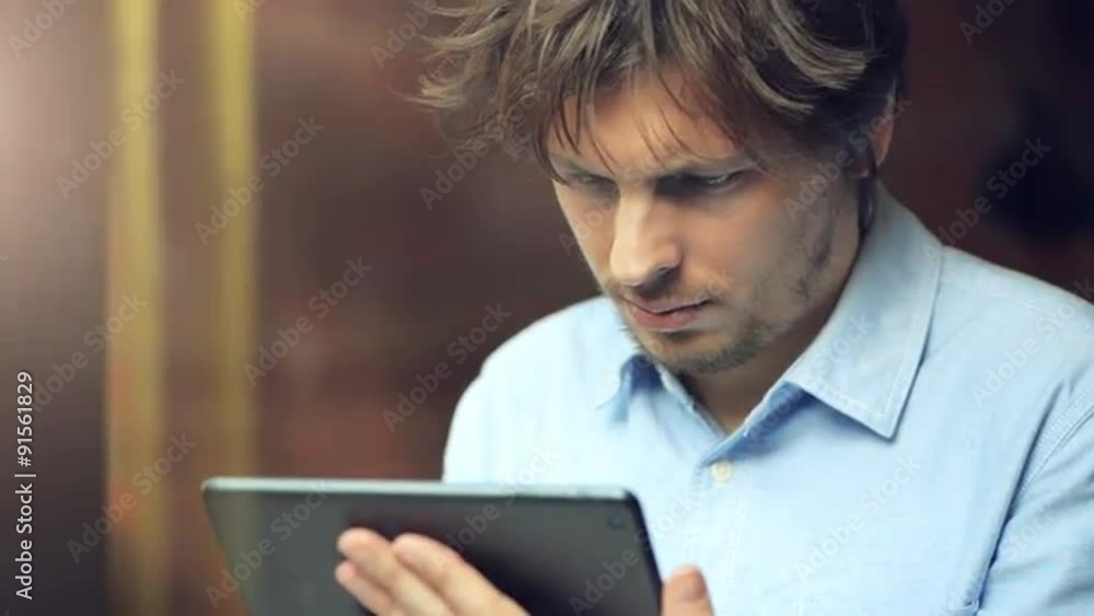 man using tablet computer touchscreen in cafe man using tablet computer touchscreen in cafe