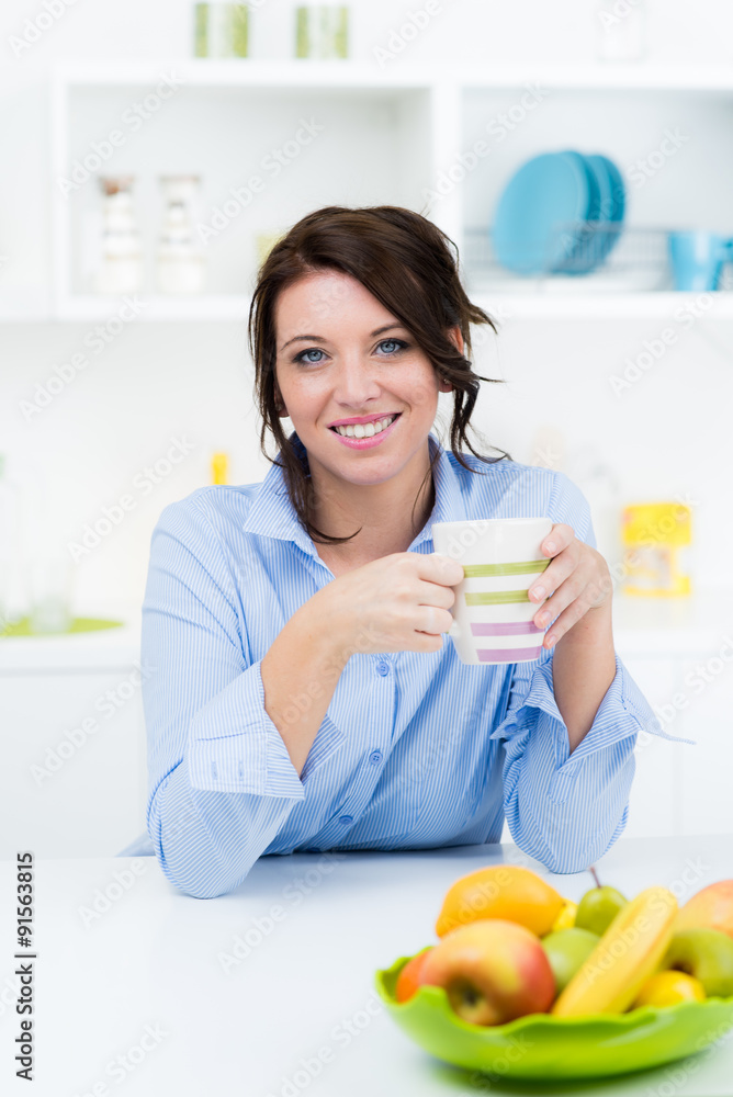 Hübsche Frau mit Tasse in Küche Hübsche Frau mit Tasse in Küche