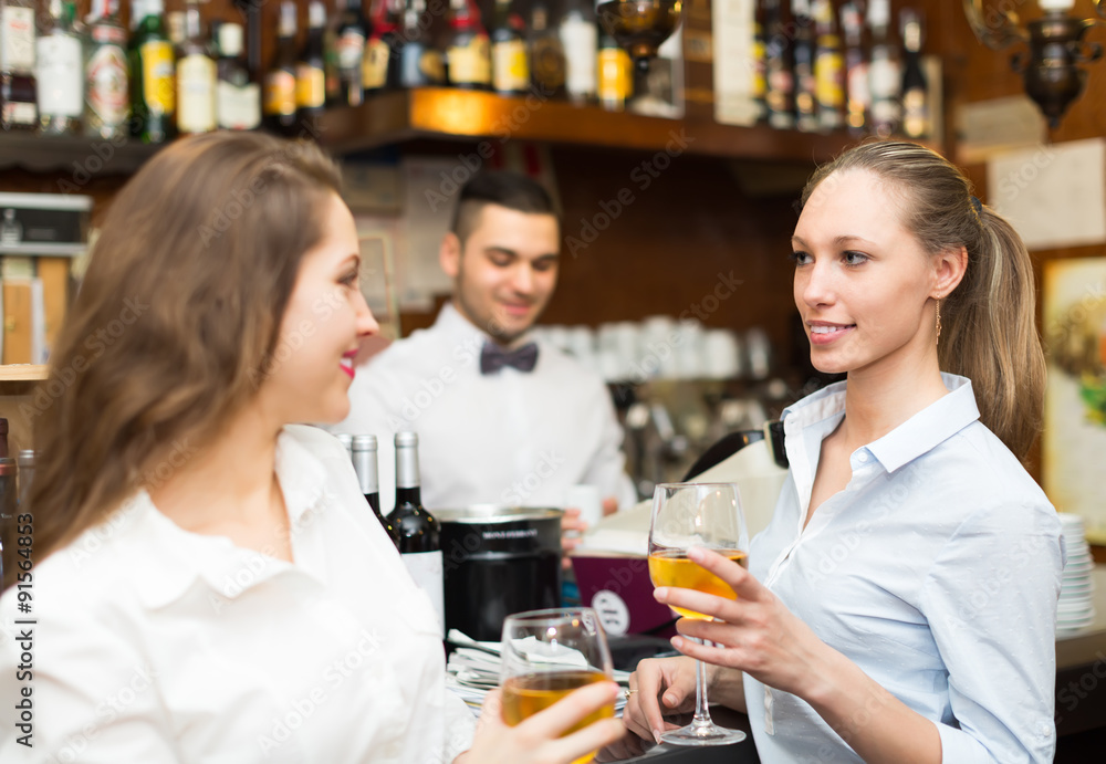 Two girls flirting with barman