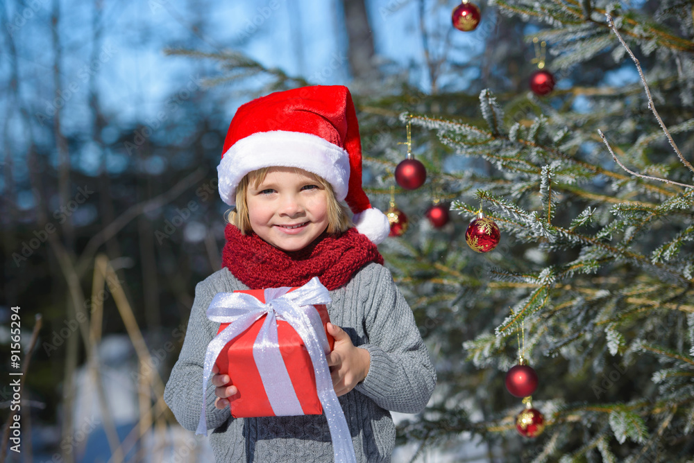 Portrait of cute little boy with christmas gift in the winter forest Portrait of cute little boy with christmas gift in the winter forest