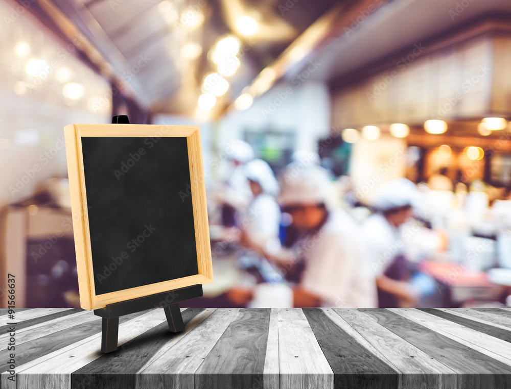 Blackboard menu with easel on wooden table with blur open kitche - obrazy, fototapety, plakaty 