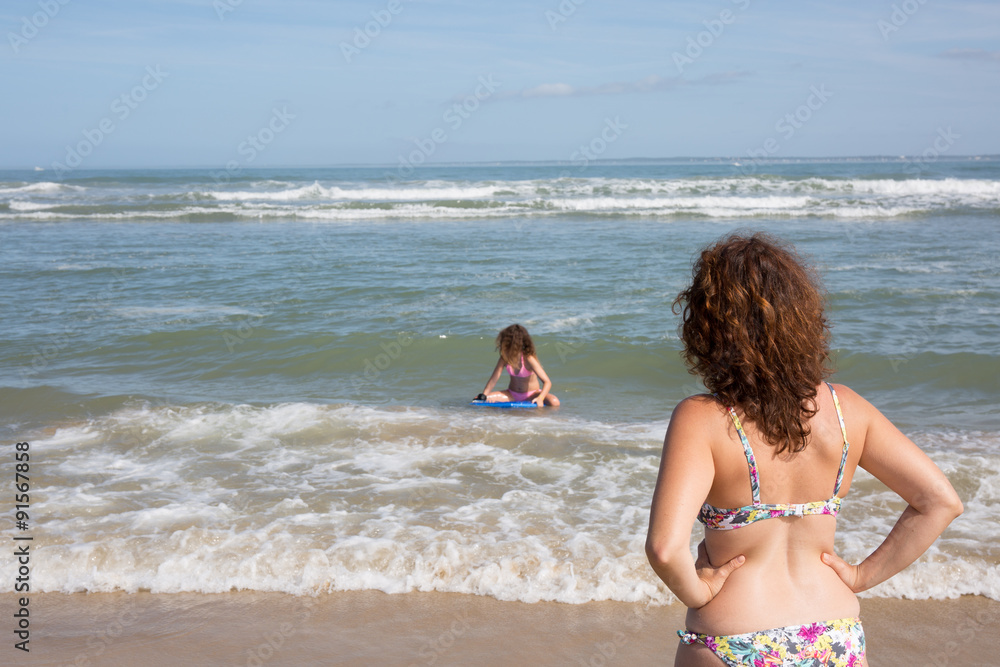 Woman on beach, Rear view of y woman wearing bikini Woman on beach, Rear view of y woman wearing bikini