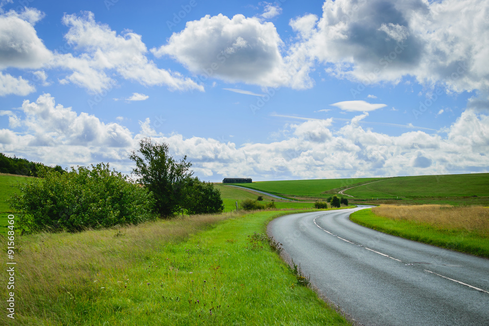 Asphalt road through the green field and blue sky cloud backgrou