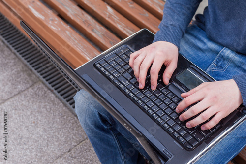 Image of man's hands typing. Selective focus. Outdoors photo.