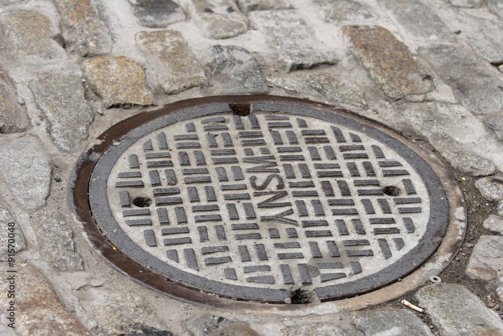 Manhole Cover on Cobblestone Street