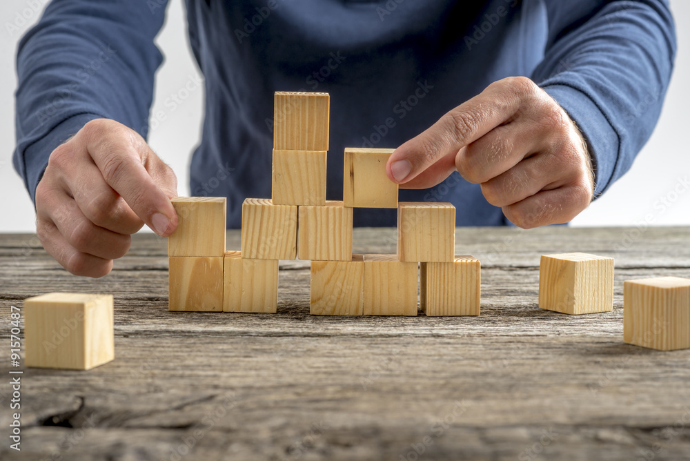 Man Assembling Wooden Cubes on Table Man Assembling Wooden Cubes on Table