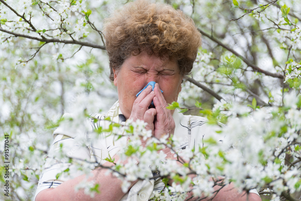 Woman with allergic rhinitis in spring garden Woman with allergic rhinitis in spring garden