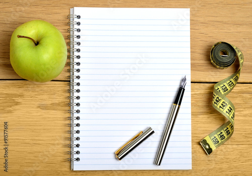 Notebook with apple fruit and centimeter