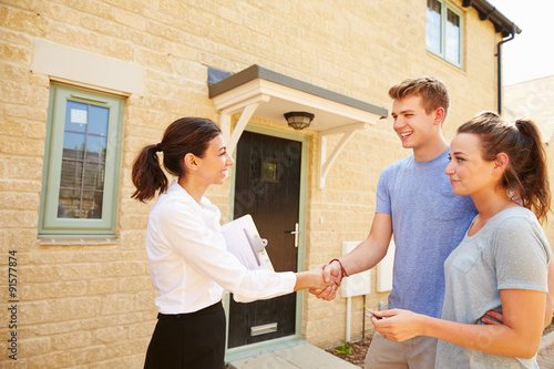 фотографія Real estate agent shaking hands with new property owners