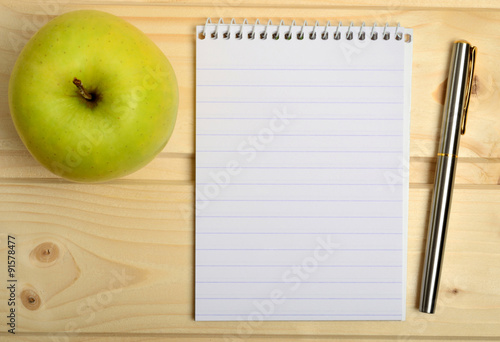 Notebook with fountain pen and apple fruit