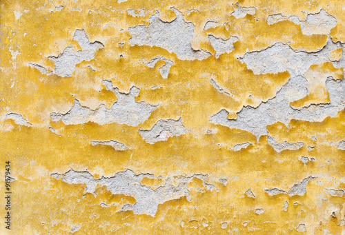 Yellow wall with damaged plaster photo