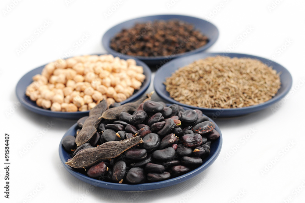 Naklejka premium beans,chick-pea, cumin and black pepper on the plates