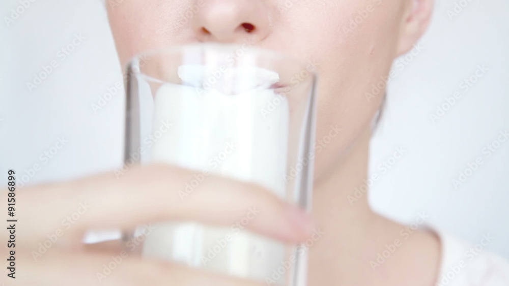 Woman drinks milk and lick off white mustache Woman drinks milk and lick off white mustache