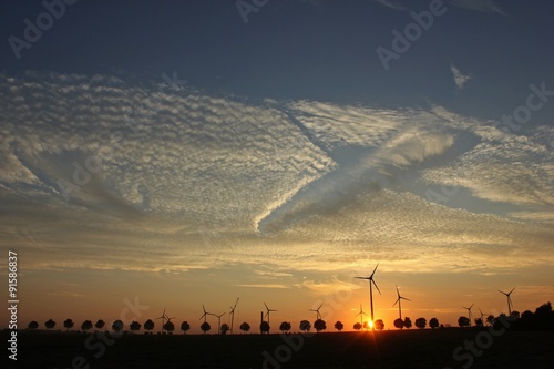 Windpark im Aufbau bei Sonnenuntergang mit Cirrocumuluswolken und Fallstreak-Muster photo