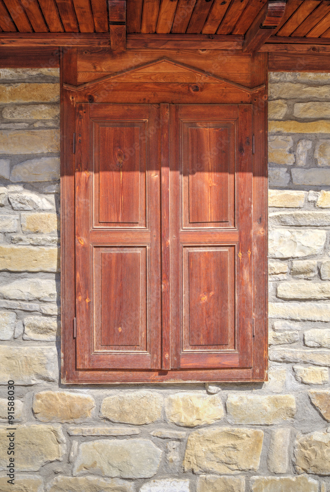Stylish wooden window on stone wall