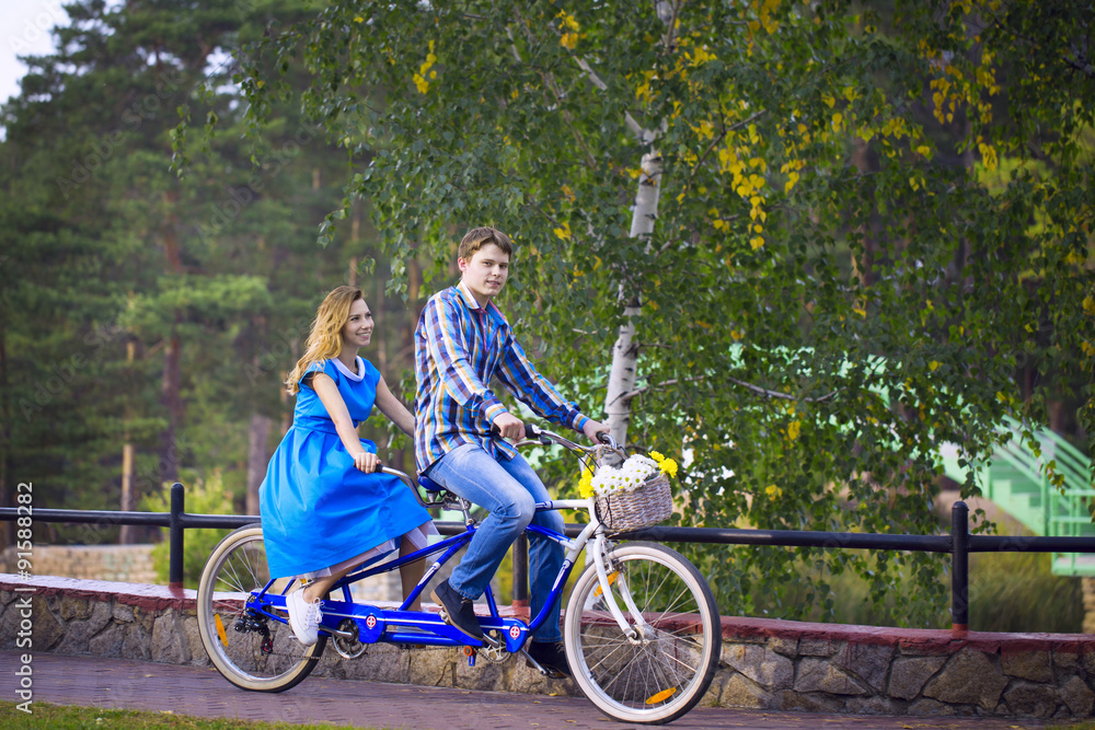 Loving couple riding on a tandem bike