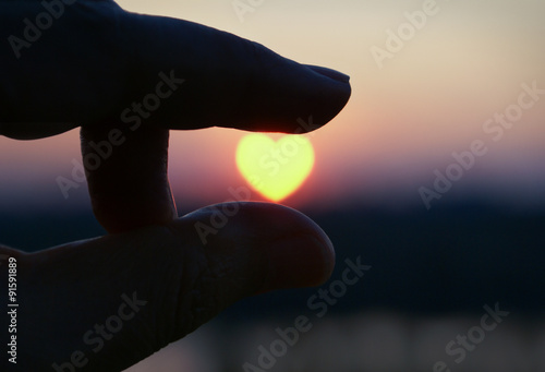Holding heart shaped sunset heart