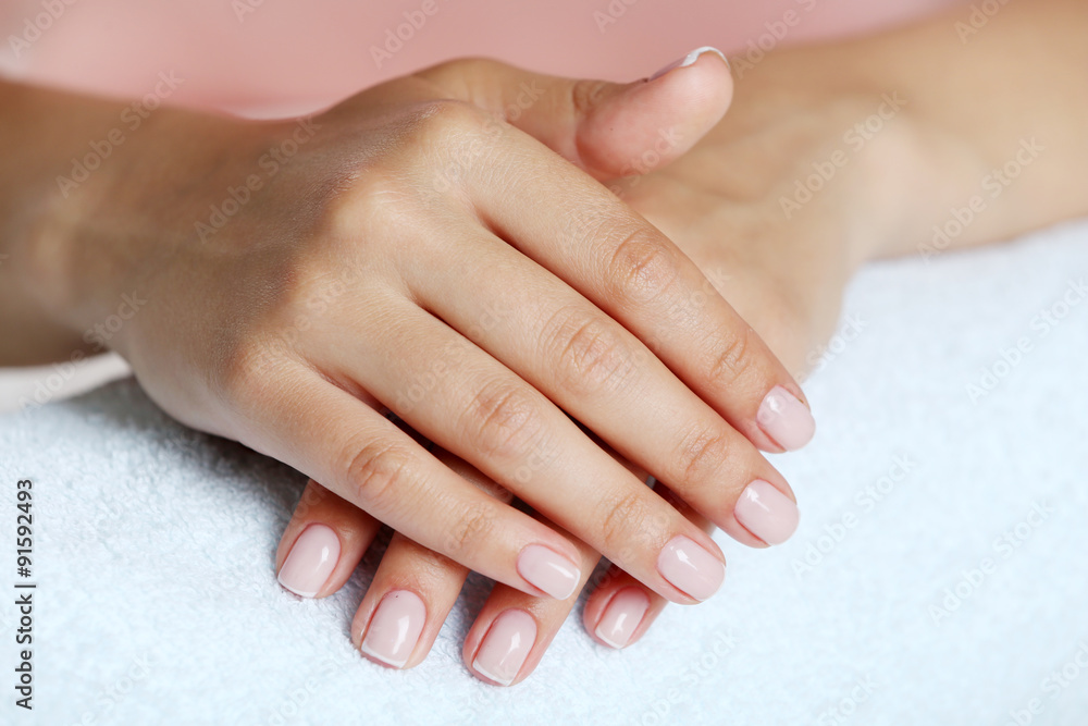 Woman hands with french manicure on towel close-up