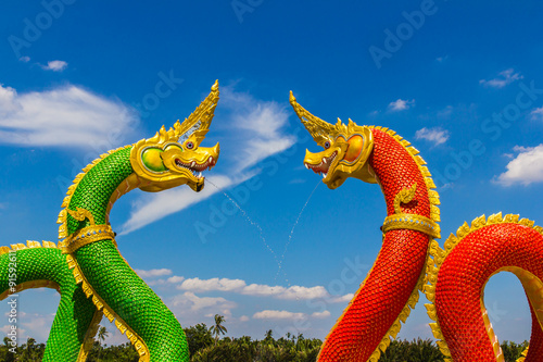 The Big Naga snake guarding Thai temple with white cloud and blue sky background