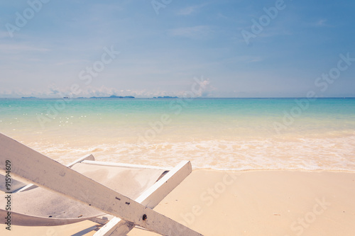 Fototapeta Naklejka Na Ścianę i Meble -  beach chair on beach with blue sky - soft focus with film filter