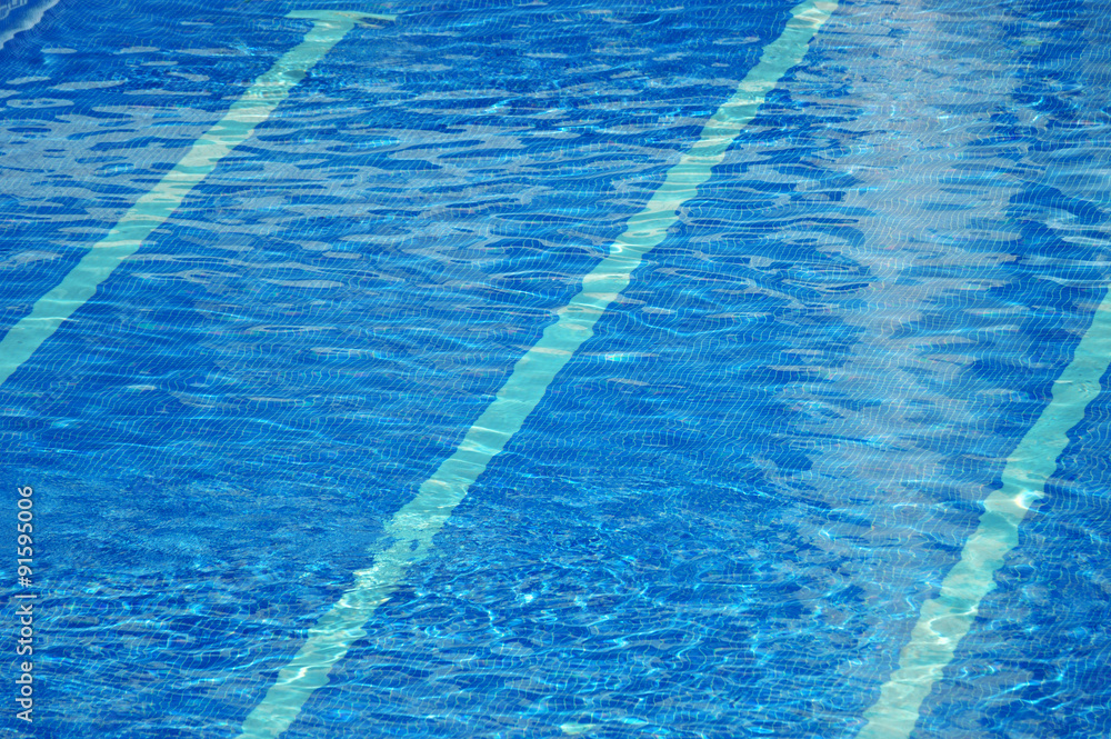 Clear blue water ripples in a swimming pool. Empty copy space for editor's text