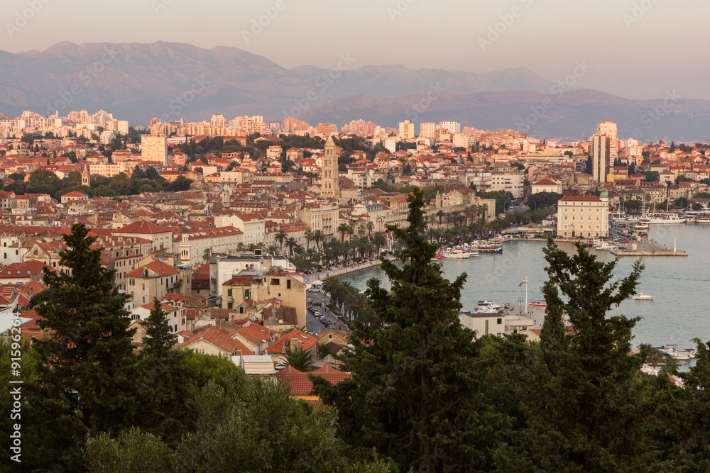 View of Split's harbour, historic old town and beyond from above in Croatia at sunset.