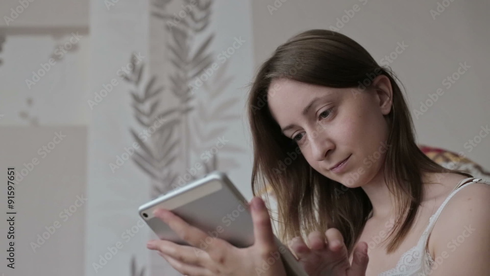 Woman at home relaxing in rocker, armchair and using tablet Woman at home relaxing in rocker, armchair and using tablet