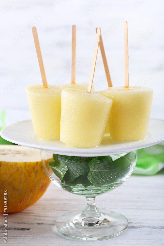Fototapeta premium Melon ice lolly on table on light blurred background