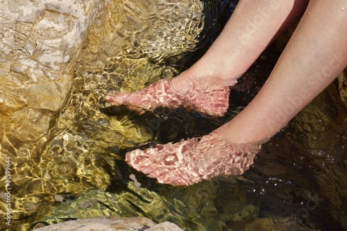 Beautiful woman legs in a mountain stream