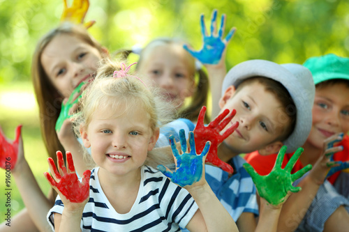 Happy active children with bright colored palms in park