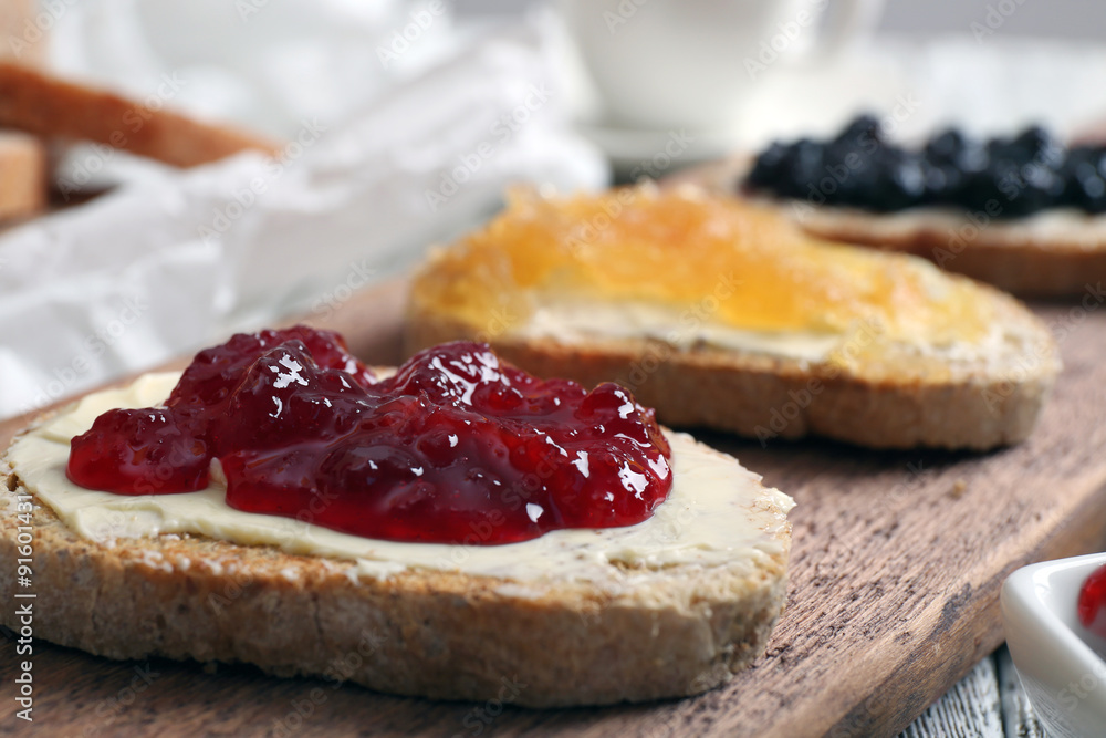 Fresh toast with butter and different jams on table close up Fresh toast with butter and different jams on table close up