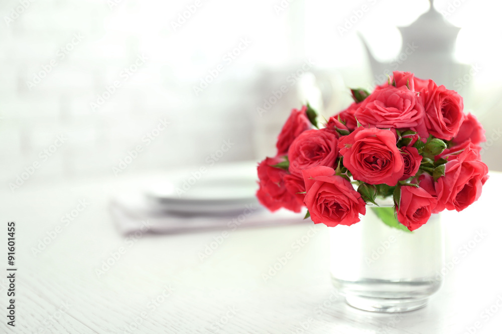 Beautiful flowers in vase on table, on light background Beautiful flowers in vase on table, on light background