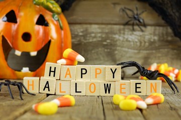 Happy Halloween wooden blocks with candy corn and decor against an old wood background
