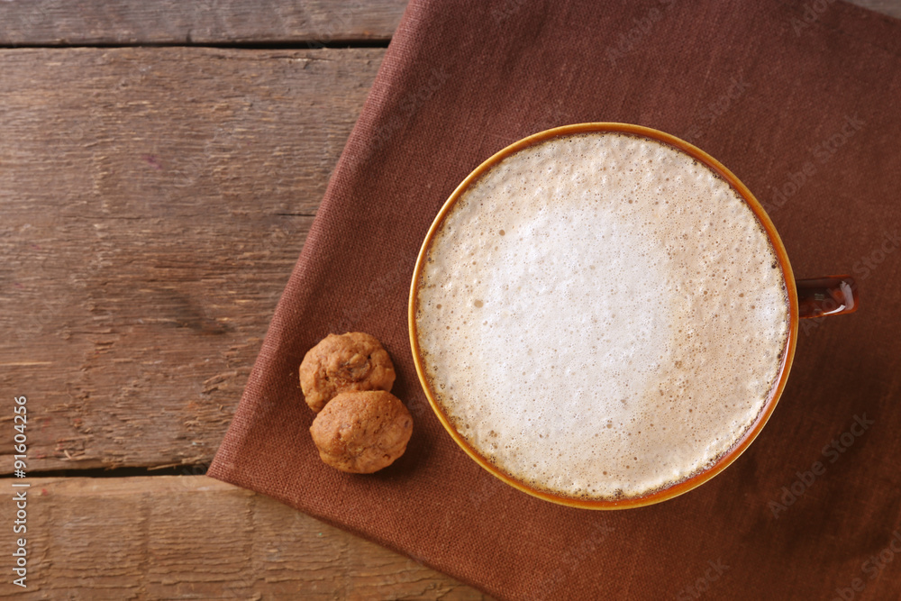 Cup of coffee and biscuits on napkin on wooden background Cup of coffee and biscuits on napkin on wooden background