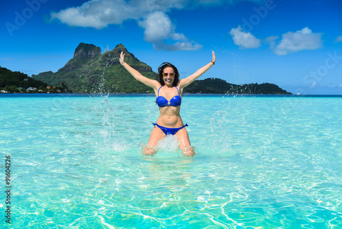 Girl with blu nikini jumping in Bora Bora