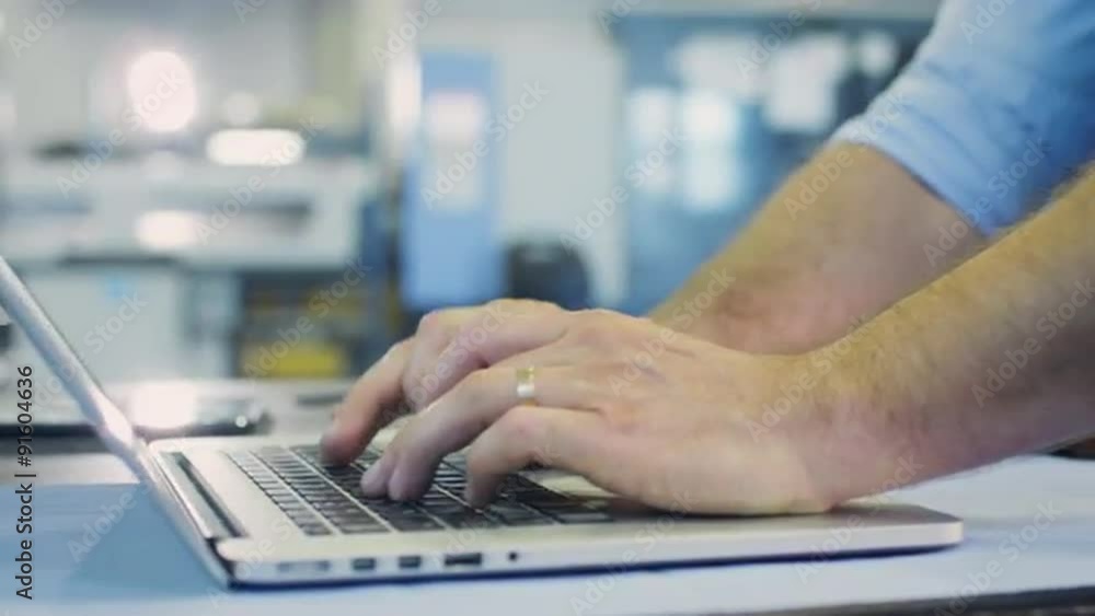 Engineer is Typing on Laptop in Industrial Environment