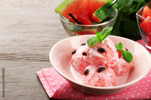 Watermelon ice cream in bowl on color wooden background