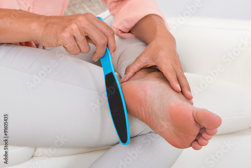 Close-up Of Woman Filing Foot photo