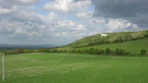 A giant white horse is a landmark with farm fields foreground in Westbury, England. photo