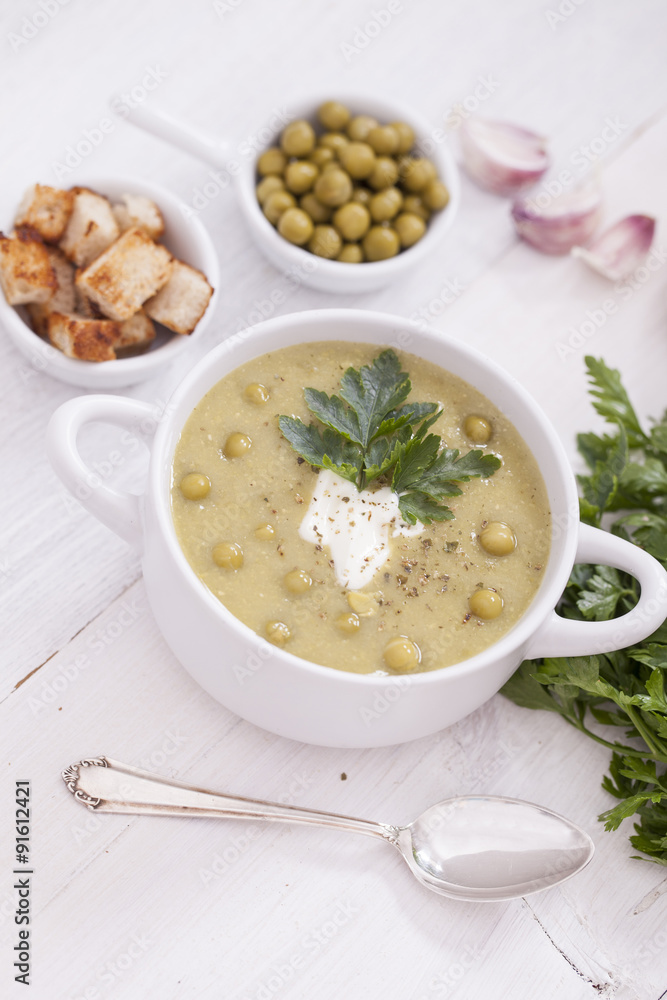 A delicious pea cream with aromatic spices on a wooden table. A delicious pea cream with aromatic spices on a wooden table.