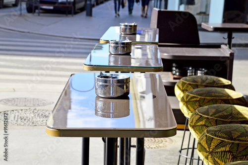 Edelstahl-Aschenbecher auf Stehtischen vor einem Restaurant photo