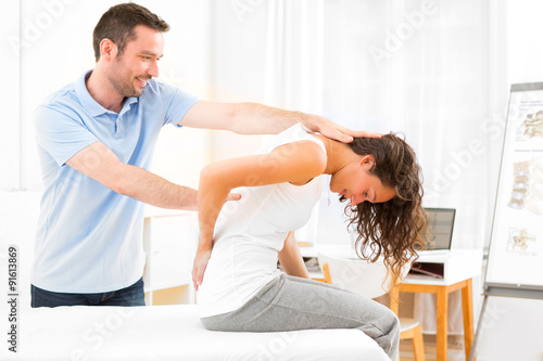 Young attractive woman being manipulated by physiotherapist