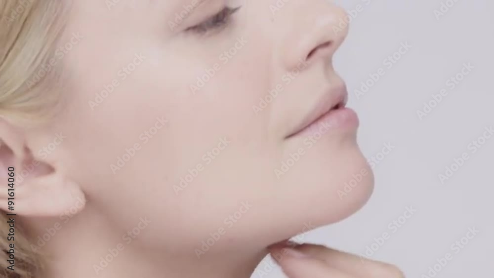 Beautiful healthy woman stroking neck touching skin in slow motion for beauty skincare concept on a grey background Red Epic Dragon Beautiful healthy woman stroking neck touching skin in slow motion for beauty skincare concept on a grey background Red Epic Dragon