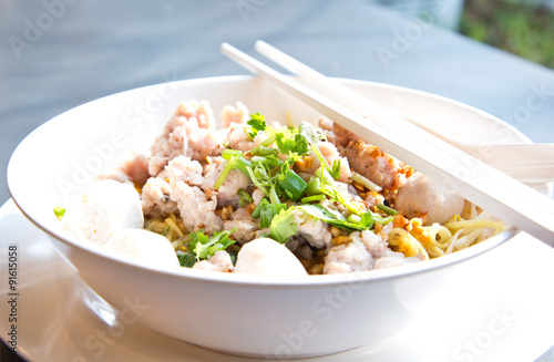 bowl of egg noodles with minced prok and fish balls photo