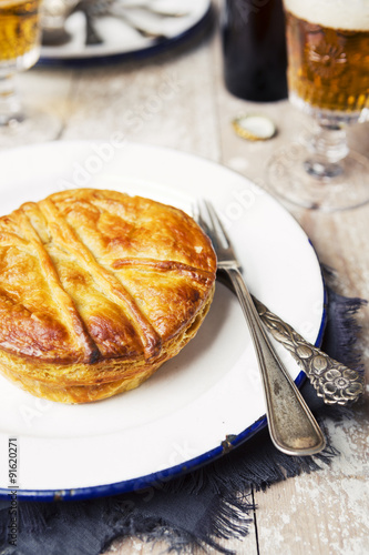 Homemade meat pie and beer on a rustic table