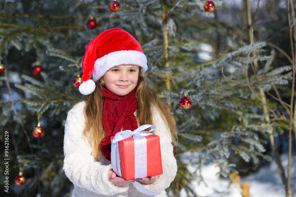 Smiling little girl with christmas gift in the winter forest Smiling little girl with christmas gift in the winter forest