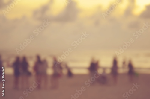 Blur people on sunset beach abstract background.