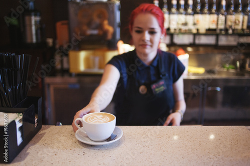 Happy girl Barista gives coffee  to the customers